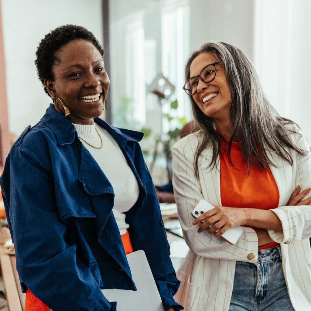 Creative co-working environment with diverse women colleagues chatting and laughing in a vibrant workplace